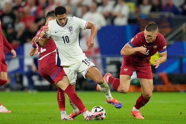 Jude Belingham berduel di laga Inggris vs Serbia. Foto:  (c) AP Photo/Andreea Alexandru